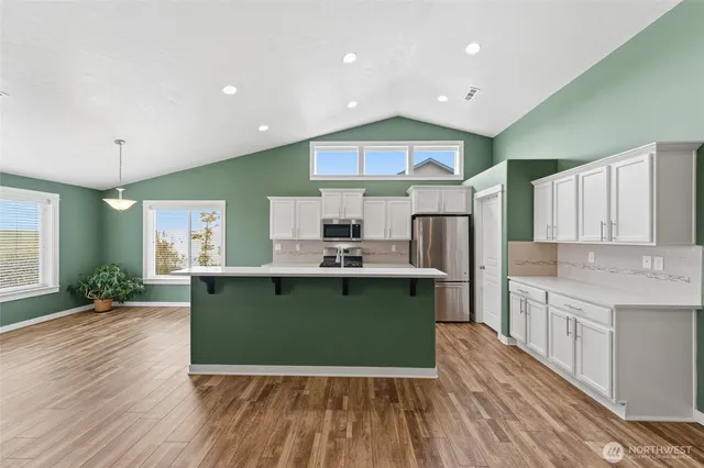 a kitchen with kitchen island granite countertop a sink a stove and cabinets