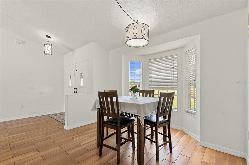 9917 Nelson Road Dade City, FL 33525 - Photo 20 of 40 a view of a dining room with furniture and wooden floor