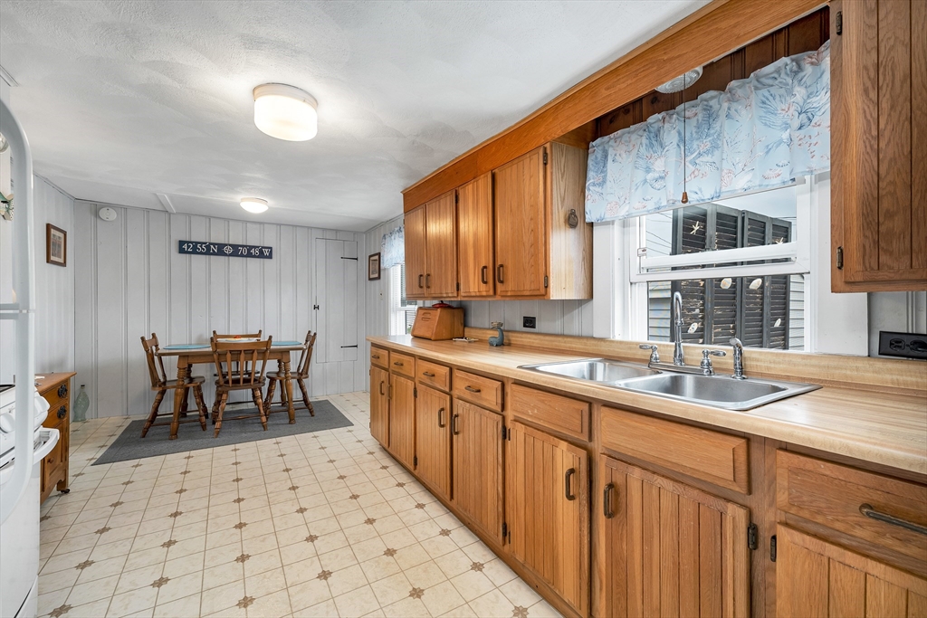 558 Winnacunnet Road Hampton, NH 03842 - Photo 21 of 40 a kitchen with a sink and chairs