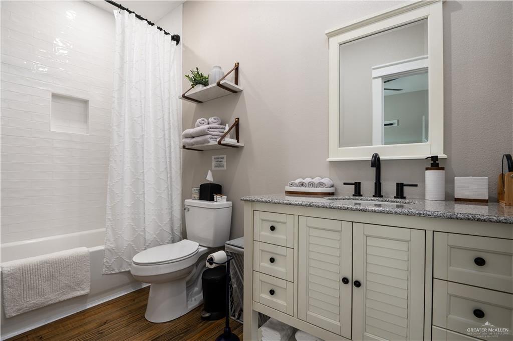 1053 Johnson Road Port Bolivar, TX 77617 - Photo 18 of 27 a bathroom with a granite countertop sink toilet and mirror