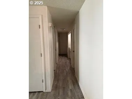 a view of a hallway with wooden floor