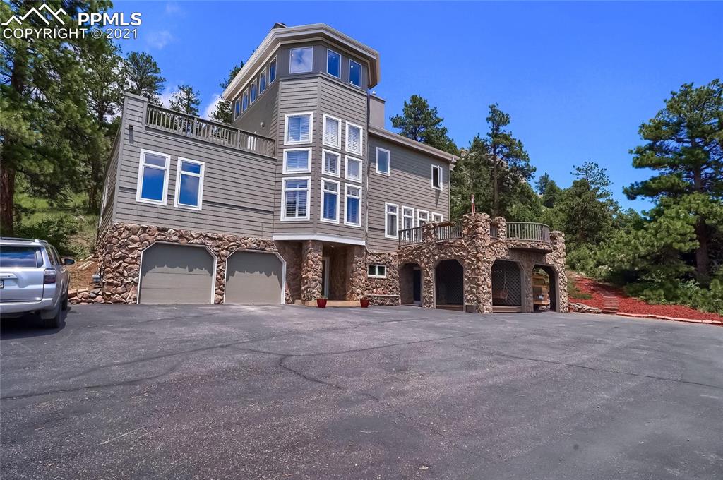 623 West Meadow Road Evergreen, CO 80439 - Photo 1 of 49 a front view of a house with a yard and garage