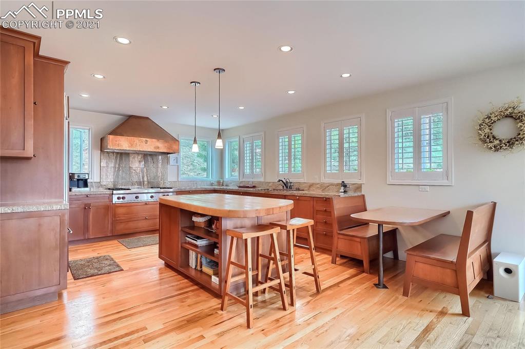 623 West Meadow Road Evergreen, CO 80439 - Photo 19 of 49 a kitchen with stainless steel appliances granite countertop a stove a sink a oven a dining table and chairs