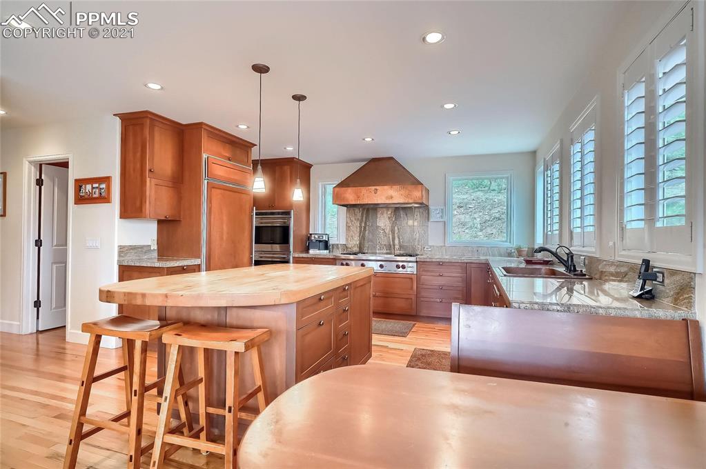 623 West Meadow Road Evergreen, CO 80439 - Photo 20 of 49 a large kitchen with kitchen island a large counter top space a sink stainless steel appliances and windows