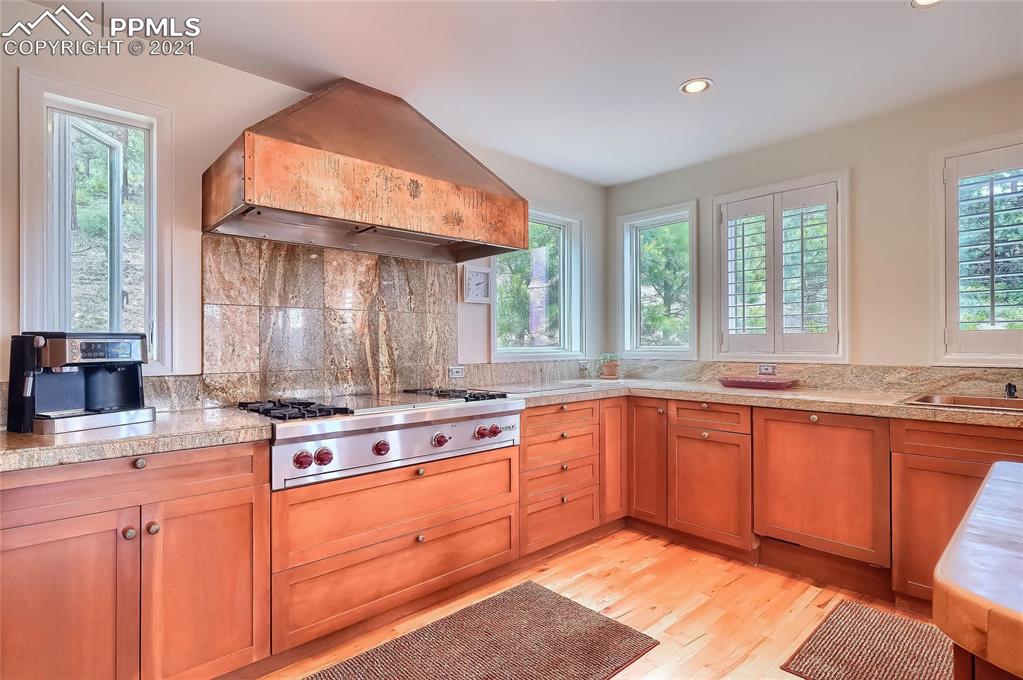 623 West Meadow Road Evergreen, CO 80439 - Photo 21 of 49 a kitchen with stainless steel appliances granite countertop a stove a sink and a microwave
