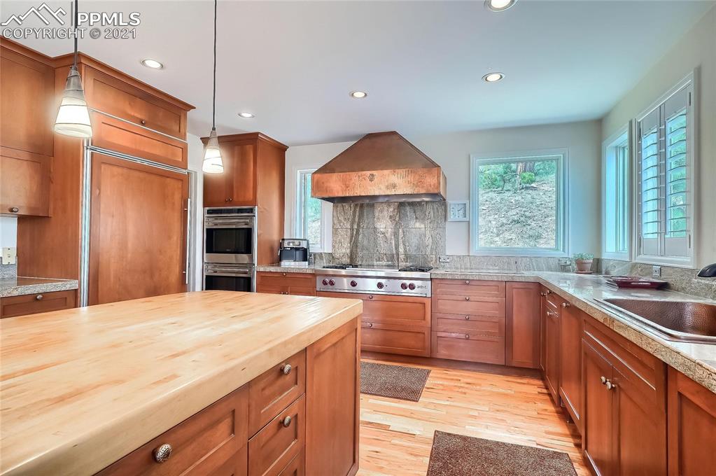 623 West Meadow Road Evergreen, CO 80439 - Photo 23 of 49 a large kitchen with stainless steel appliances a large counter top a sink a stove and a refrigerator