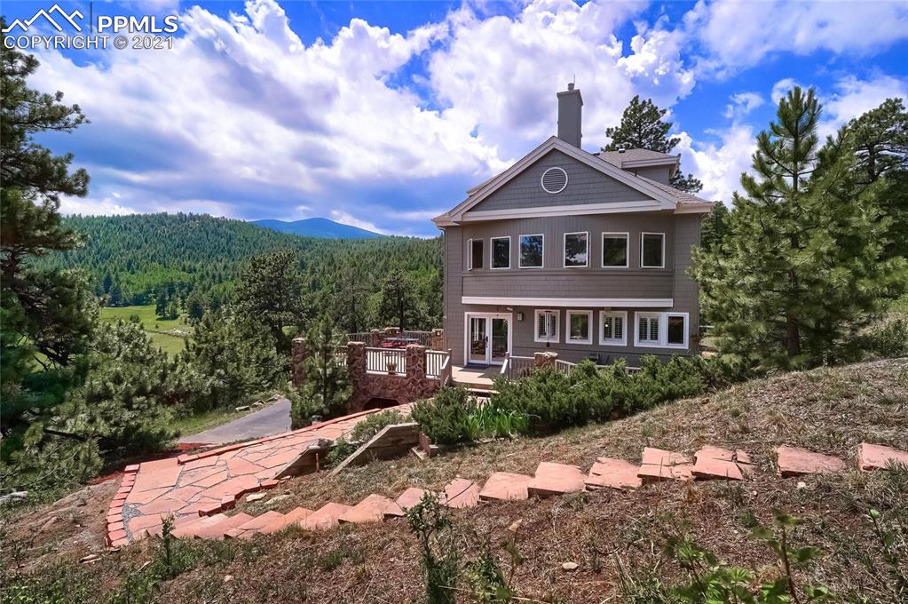 623 West Meadow Road Evergreen, CO 80439 - Photo 5 of 49 a view of a big house with a big yard and large trees