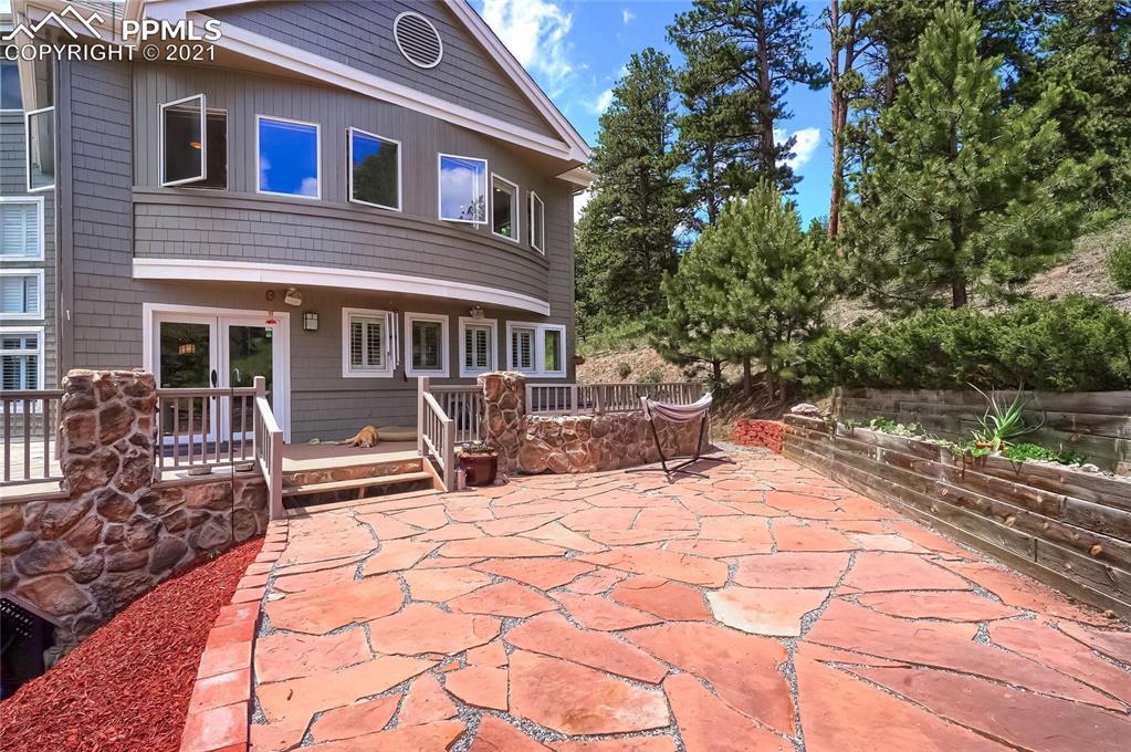 623 West Meadow Road Evergreen, CO 80439 - Photo 46 of 49 a patio with a table and chairs and potted plants