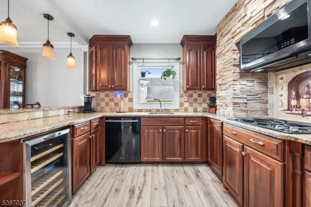 a kitchen with stainless steel appliances granite countertop wooden cabinets a stove top oven a sink and dishwasher