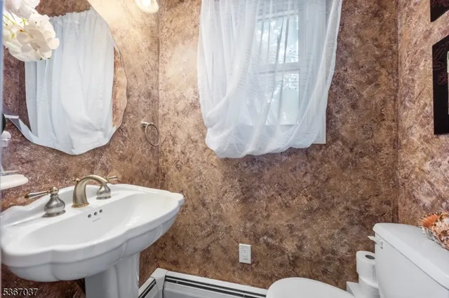 a bathroom with a sink and mirror with toilet