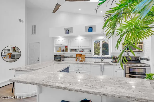 a kitchen with stainless steel appliances granite countertop a sink and a stove