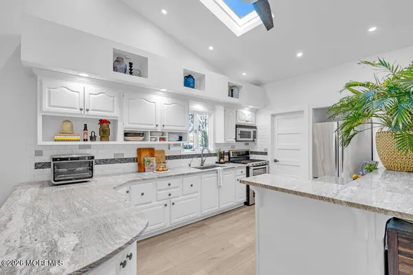 a kitchen with stainless steel appliances kitchen island granite countertop a sink and cabinets