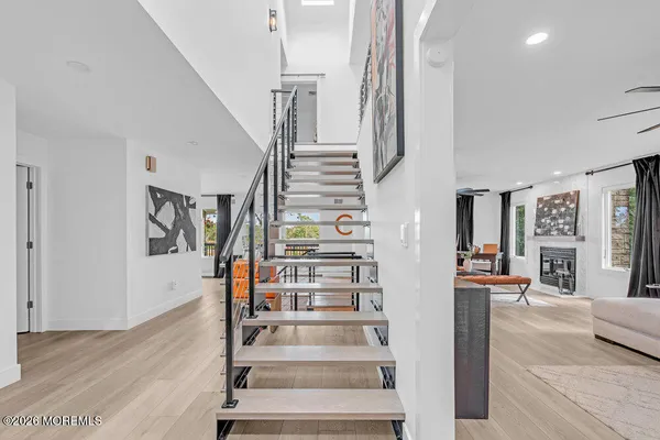 a view of staircase with lots of frames on wall and wooden floor