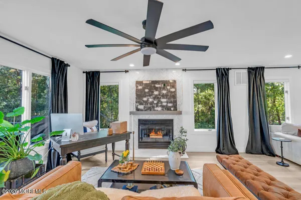 a living room with furniture large window and a fireplace