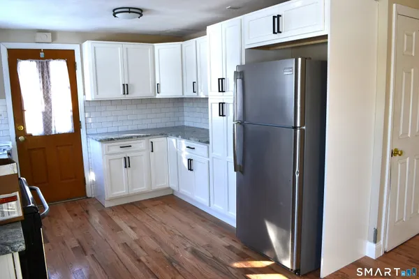 a kitchen with a refrigerator sink and cabinets