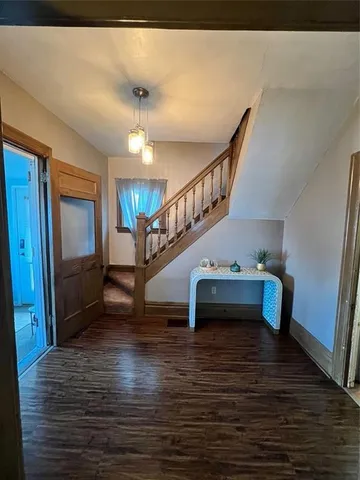 a view of entryway and hall with wooden floor