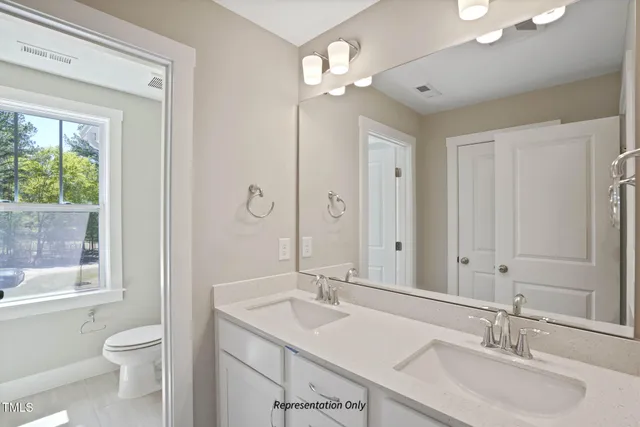 a bathroom with a sink a toilet and a large mirror