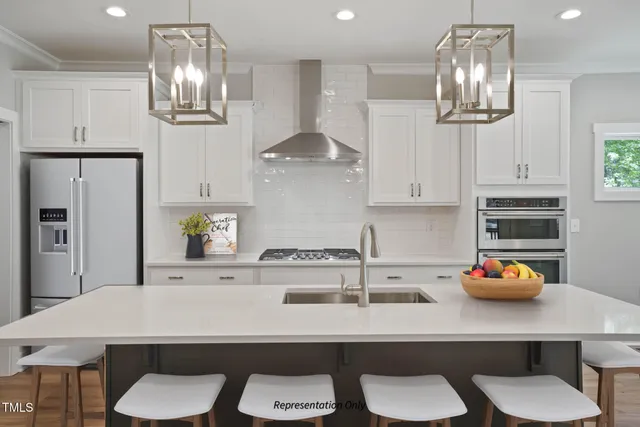 a kitchen with stainless steel appliances a table and chairs in it