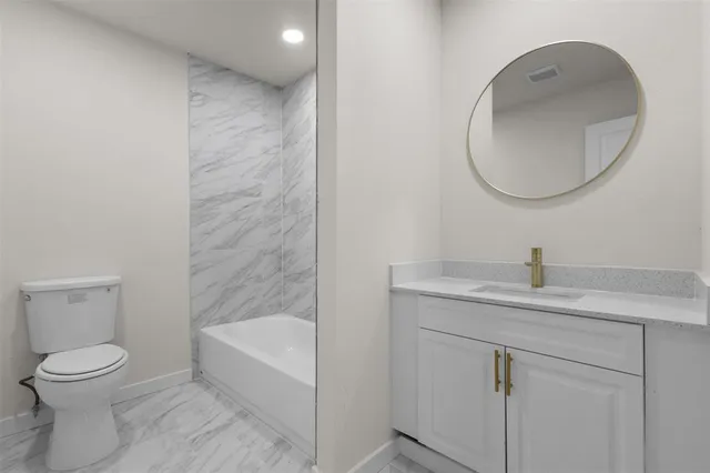 a bathroom with a toilet a sink and mirror