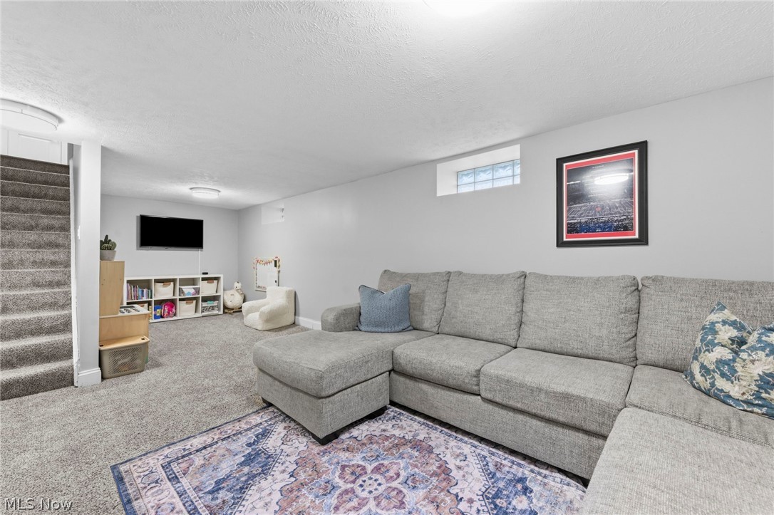 3525 Silsby Road Cleveland, OH 44118 - Photo 32 of 44 Carpeted living room with stairway and a textured ceiling