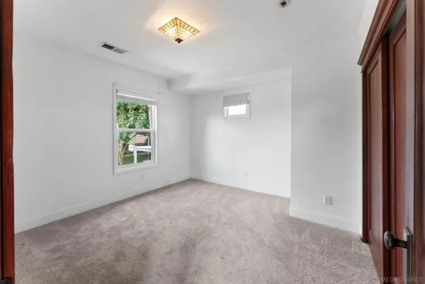 an empty room with windows and closet