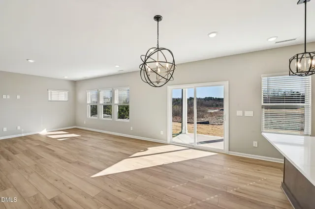 a open kitchen with stainless steel appliances granite countertop a sink a refrigerator and a wooden floor