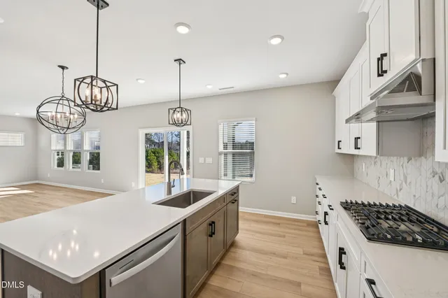 a kitchen with granite countertop white cabinets and appliances