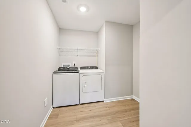 a utility room with wooden floor washer and dryer