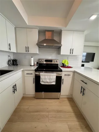 a kitchen with a white stove top oven and cabinets