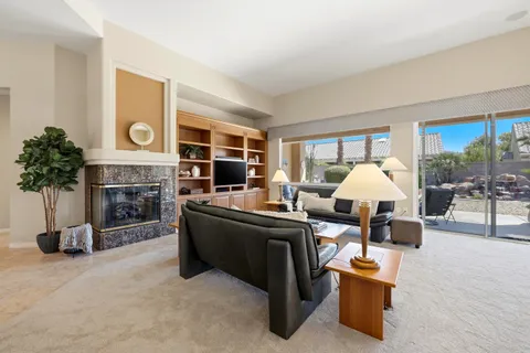 a living room with fireplace furniture and a large window