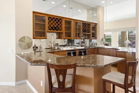 a kitchen with stainless steel appliances granite countertop a sink and a refrigerator