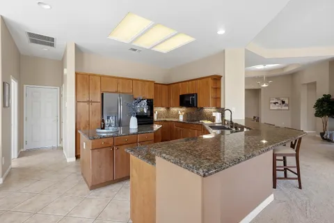 a kitchen with stainless steel appliances granite countertop a sink a stove and a refrigerator