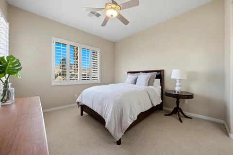 a spacious bedroom with a bed and a chandelier