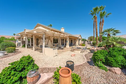 a view of a house with backyard and sitting area