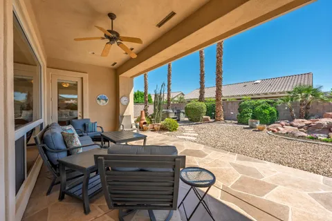 a view of a patio with a table chairs and a floor to ceiling window
