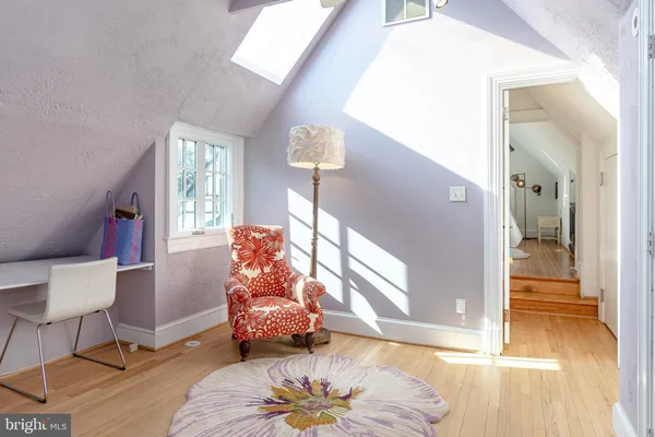a bedroom with a bed and a table with wooden floor