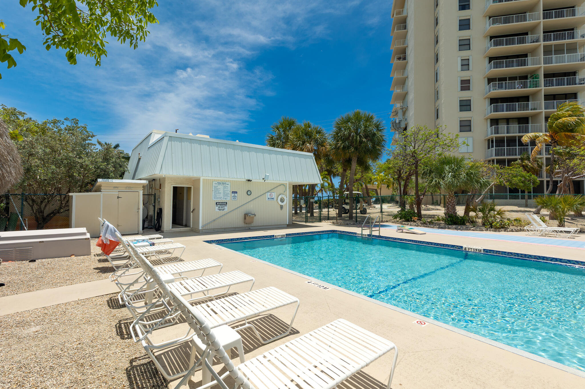 2000 Coco Plum Drive, Unit 301 Marathon, FL 33050 - Photo 33 of 57 a view of a swimming pool with a lounge chairs