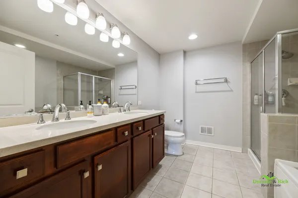 a spacious bathroom with a granite countertop sink a toilet and a mirror