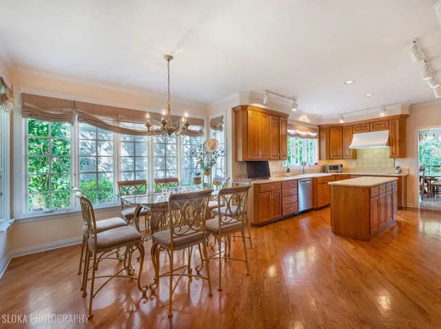 a kitchen with stainless steel appliances kitchen island wooden cabinets and dining table