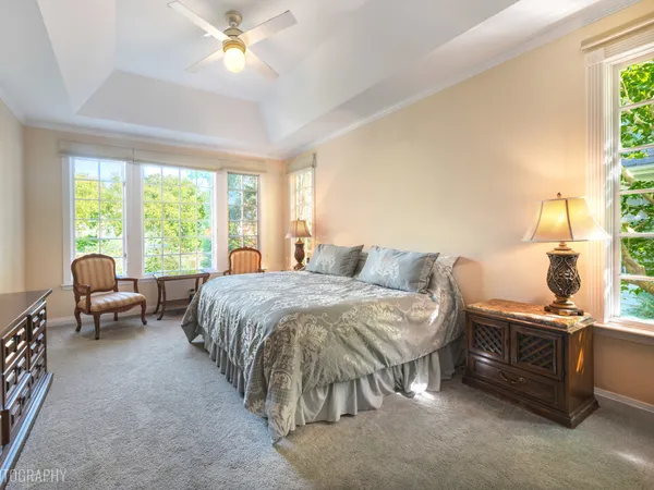 a spacious bedroom with a bed and a chandelier