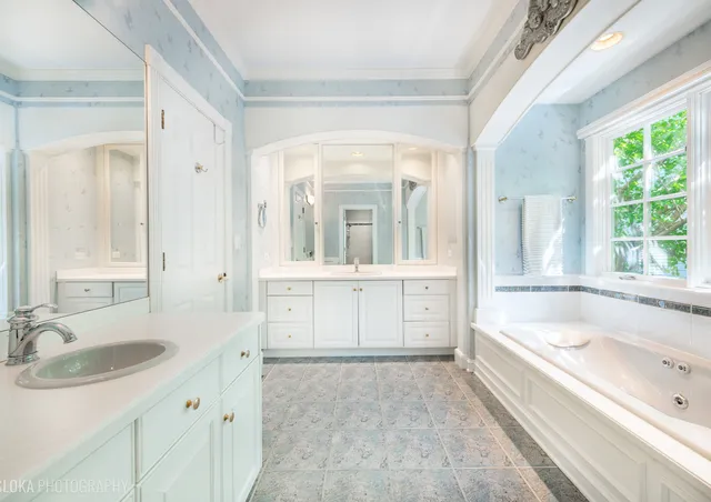 a bathroom with a tub sink and mirror