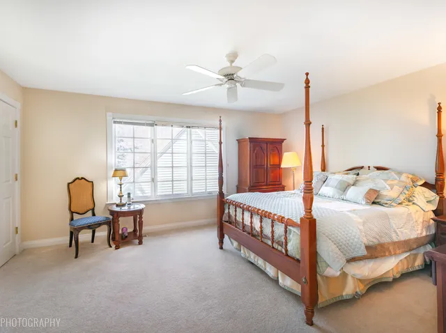 a bedroom with a bed chandelier and a window