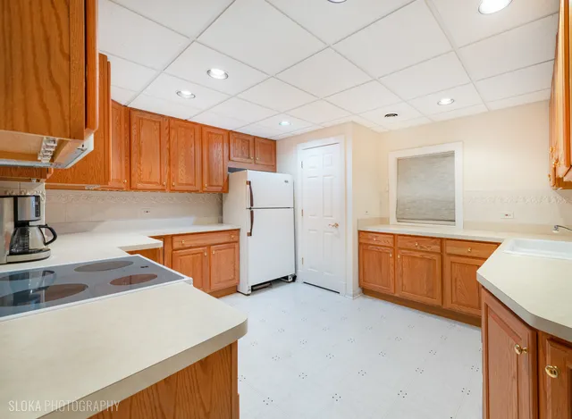 a kitchen with stainless steel appliances granite countertop a sink a stove and a refrigerator