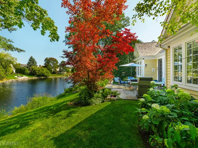 a backyard of a house with plants and lake view