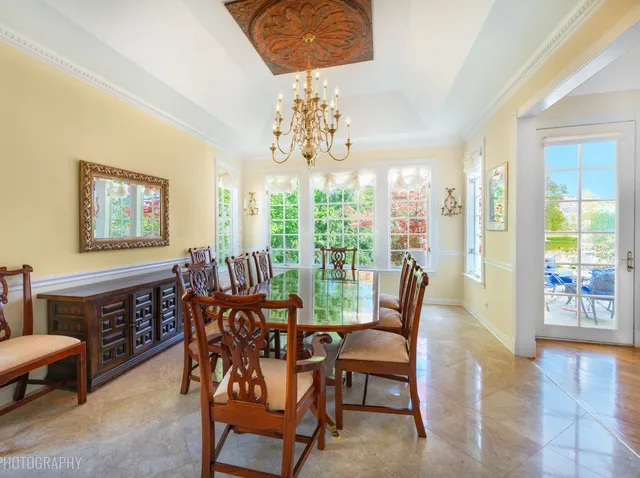 a view of a dining room with furniture a chandelier and wooden floor