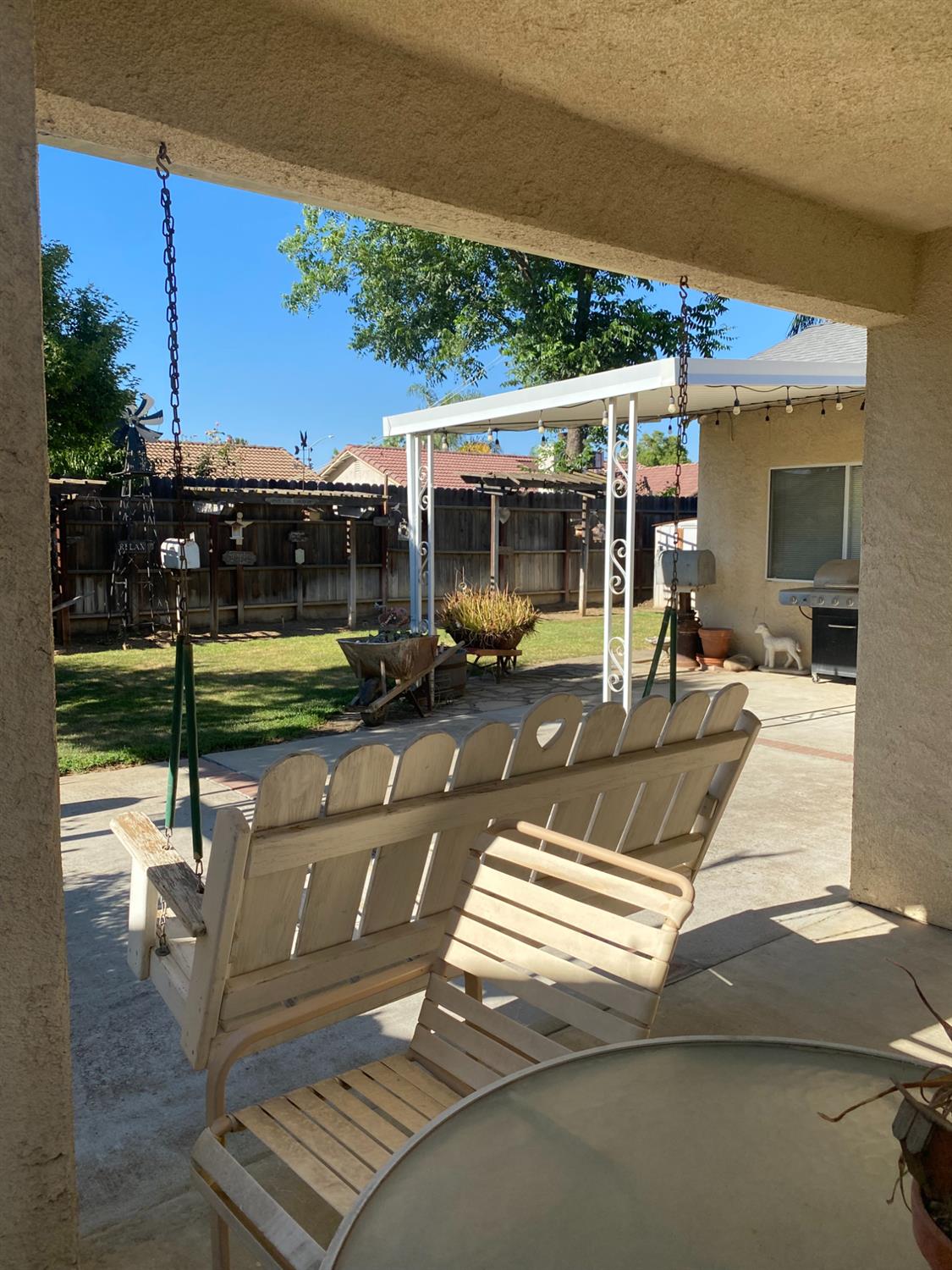 609 Merlot Avenue Madera, CA 93637 - Photo 43 of 45 a view of a patio with a table chairs potted plants and palm tree