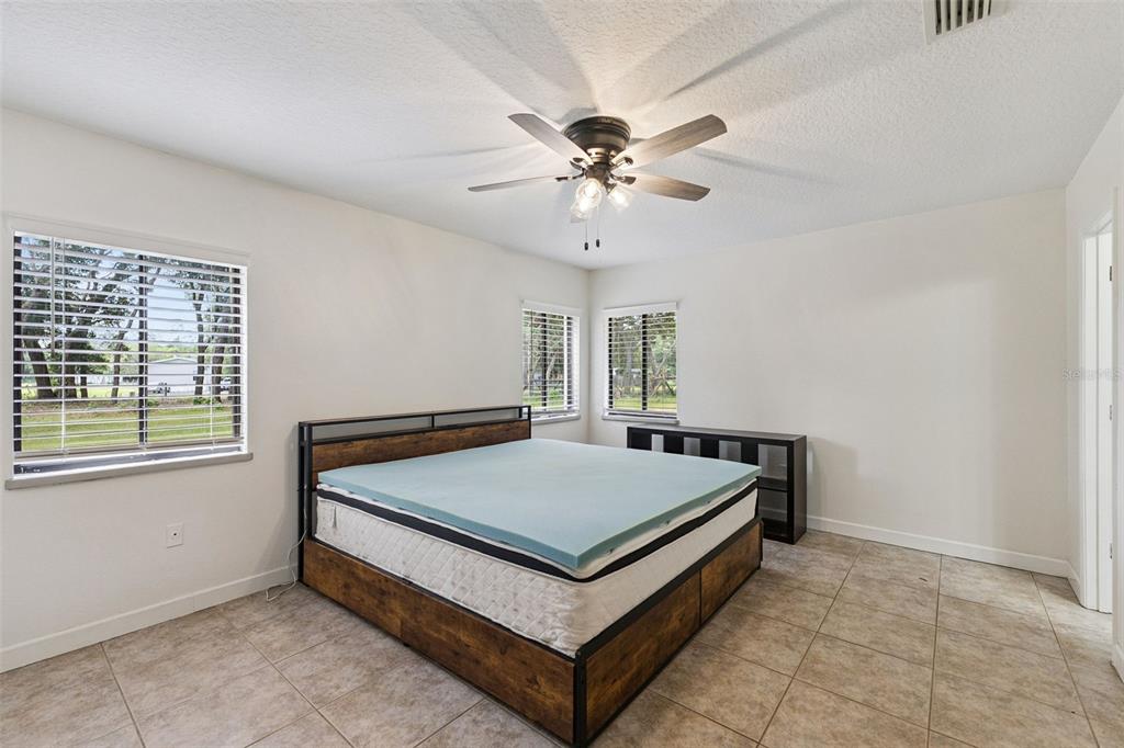 1142 Buckles Road Pierson, FL 32180 - Photo 14 of 34 a bed sitting in a spacious bedroom next to a window