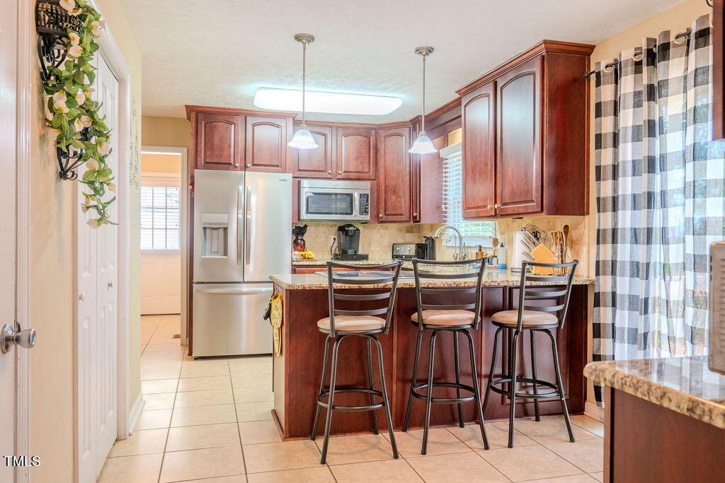 2937 Thrower Road Hope Mills, NC 28348 - Photo 10 of 20 a kitchen with stainless steel appliances granite countertop a refrigerator and a stove top oven