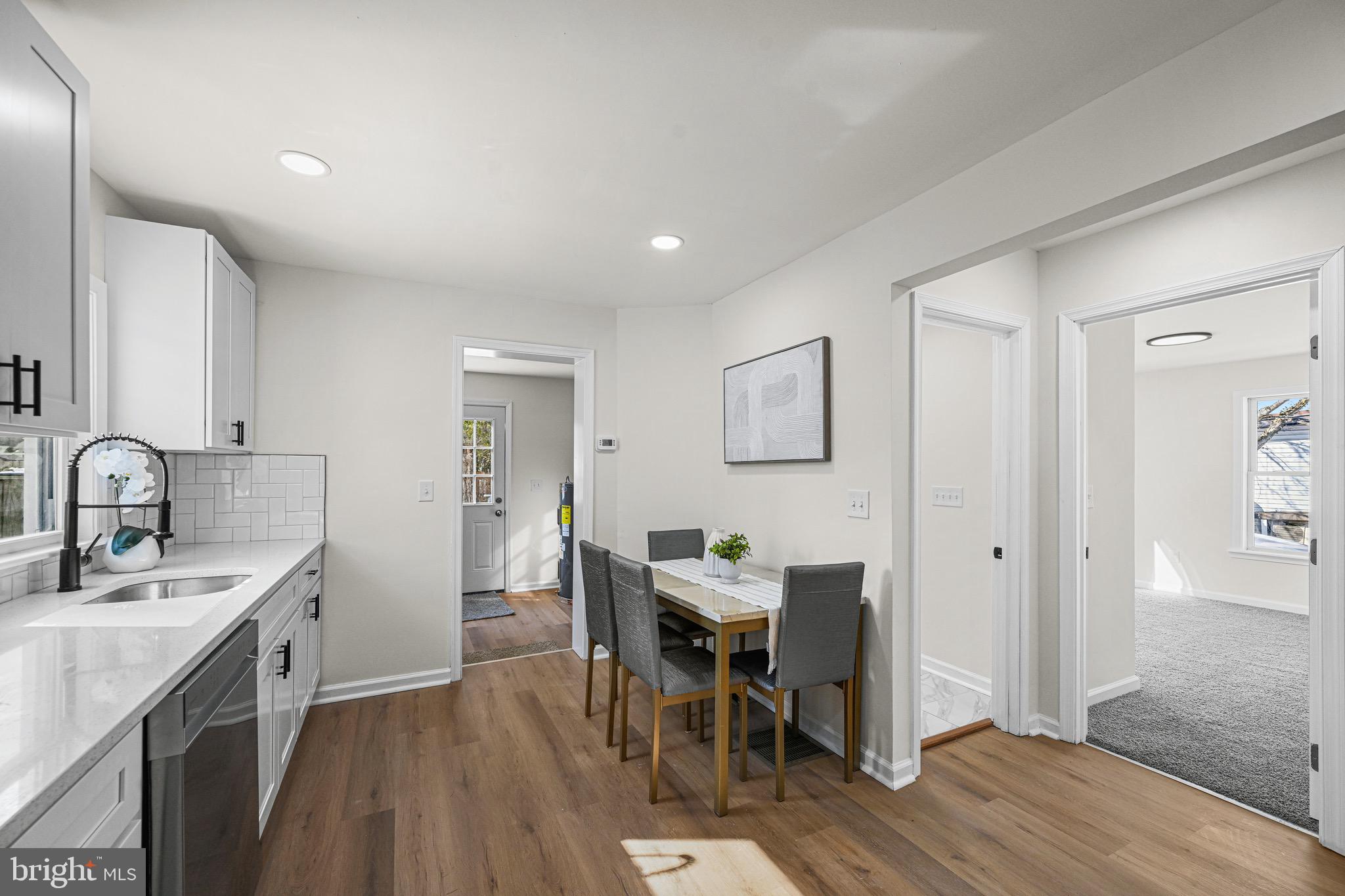 3718 4th Avenue Edgewater, MD 21037 - Photo 13 of 34 a kitchen with a table chairs refrigerator and cabinets