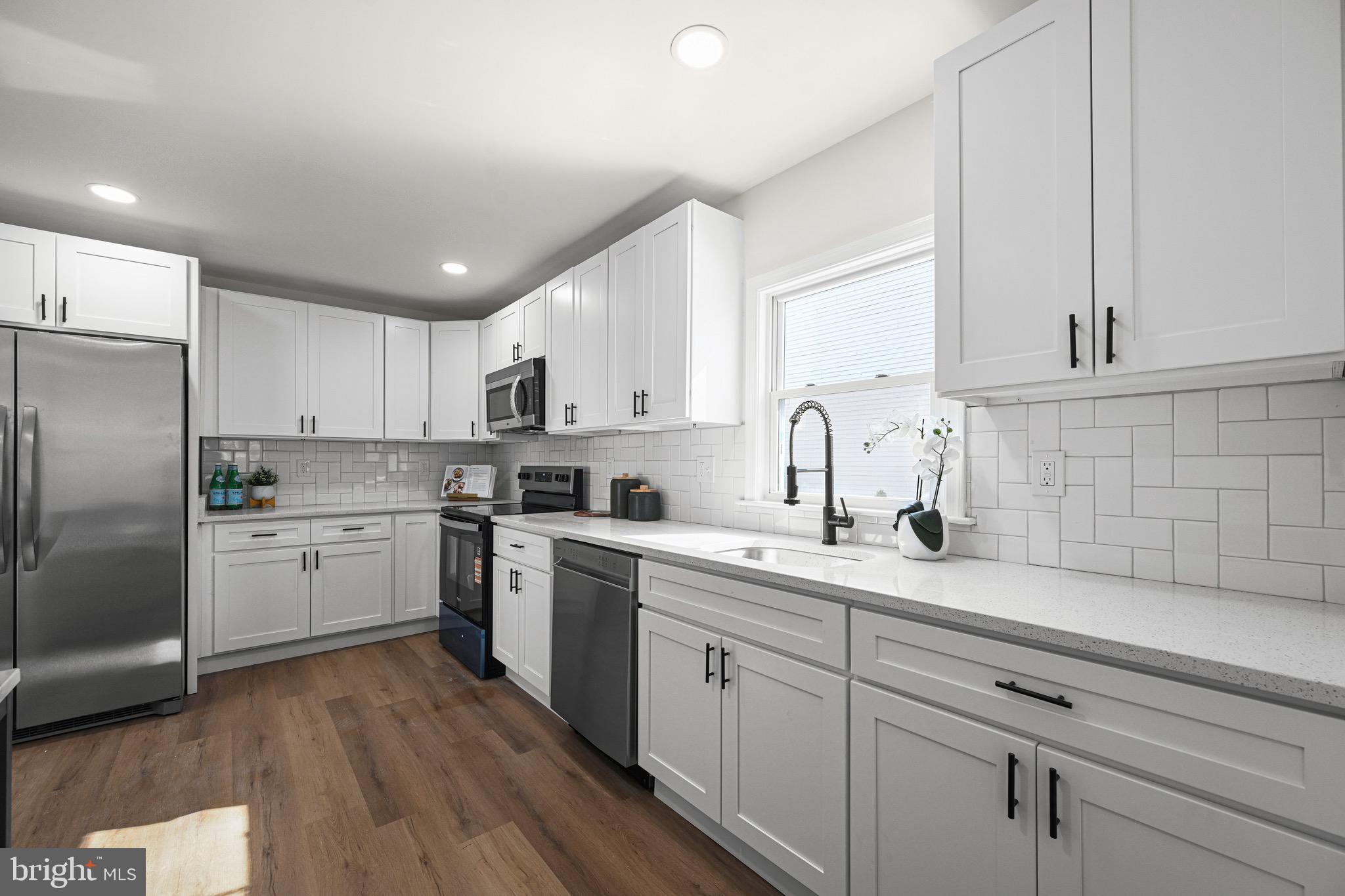 3718 4th Avenue Edgewater, MD 21037 - Photo 16 of 34 a kitchen with a sink cabinets stainless steel appliances and a window
